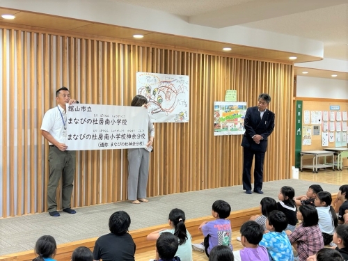 校名を伝える石井教育長(房南小学校)